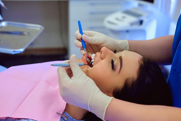 close up image of dentist examining female teeth in dentistry
